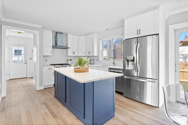 kitchen featuring white cabinetry, a center island, stainless steel appliances, plenty of natural light, and wall chimney exhaust hood