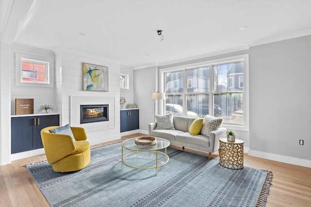 living area featuring ornamental molding and light hardwood / wood-style floors