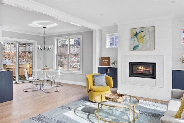 sitting room featuring crown molding, wood-type flooring, and an inviting chandelier