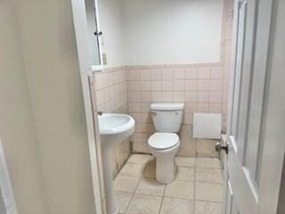 16 Fowler St, Boston, MA 02121 - bathroom featuring toilet, wainscoting, tile patterned flooring, and tile walls