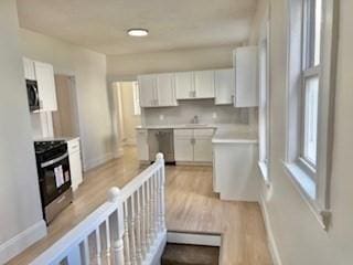 16 Fowler St, Boston, MA 02121 - kitchen featuring electric stove, baseboards, light wood-style floors, and white cabinets