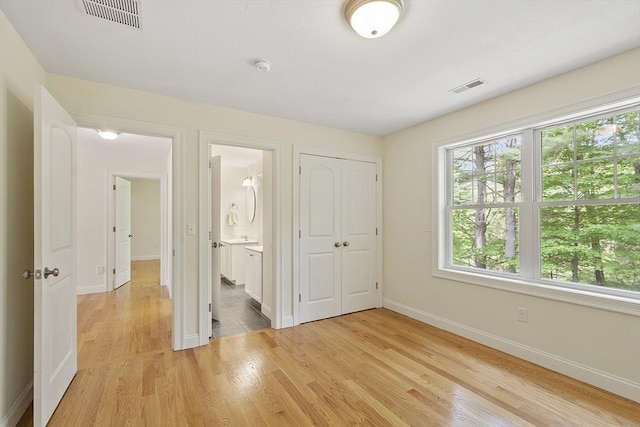 6 Beacon Ct, Acton, MA 01720 - unfurnished bedroom with multiple windows, baseboards, light wood-style floors, and a closet