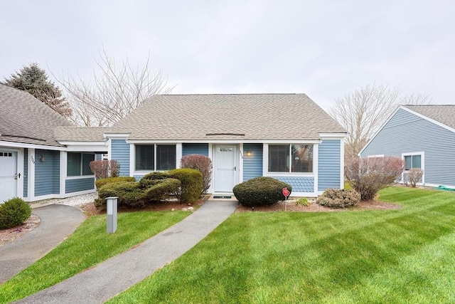 view of front of property with a front lawn and a shingled roof