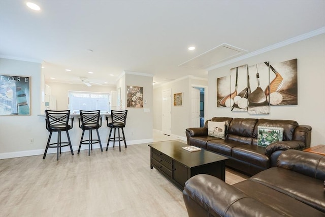 living room featuring baseboards, attic access, recessed lighting, ornamental molding, and light wood-style floors