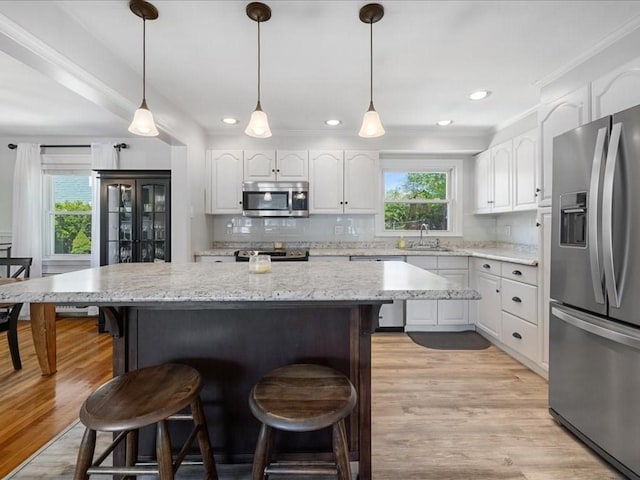 114 Hobart St, Braintree, MA 02184 - kitchen featuring a sink, stainless steel appliances, white cabinetry, and a breakfast bar area