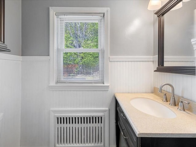 114 Hobart St, Braintree, MA 02184 - bathroom with heating unit, vanity, and wainscoting