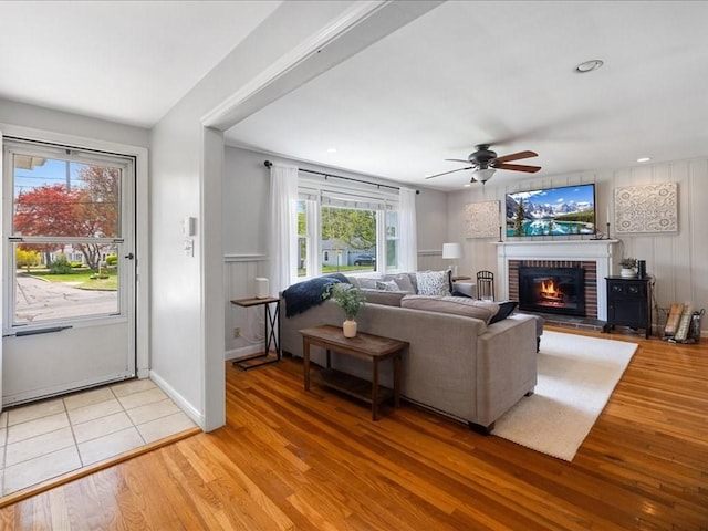 114 Hobart St, Braintree, MA 02184 - living room featuring baseboards, light wood-style flooring, a ceiling fan, and a brick fireplace