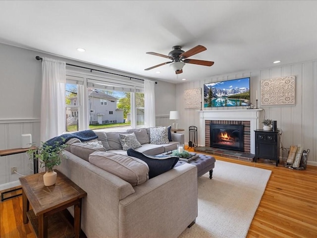 114 Hobart St, Braintree, MA 02184 - living room with a decorative wall, wood finished floors, a ceiling fan, and a brick fireplace