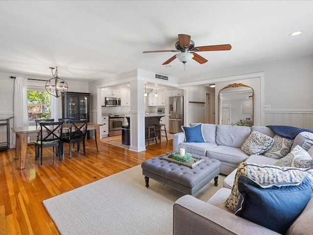 114 Hobart St, Braintree, MA 02184 - living area featuring wainscoting, light wood-style flooring, ceiling fan with notable chandelier, and visible vents