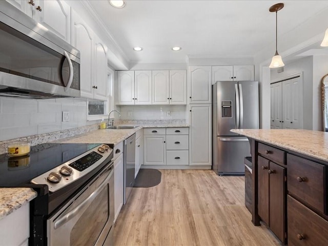 114 Hobart St, Braintree, MA 02184 - kitchen with hanging light fixtures, light wood finished floors, a sink, white cabinetry, and appliances with stainless steel finishes