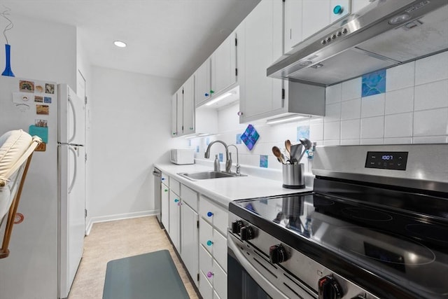 kitchen featuring appliances with stainless steel finishes, under cabinet range hood, a sink, tasteful backsplash, and light countertops