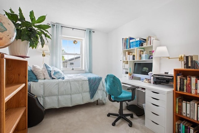 bedroom with light colored carpet and a desk