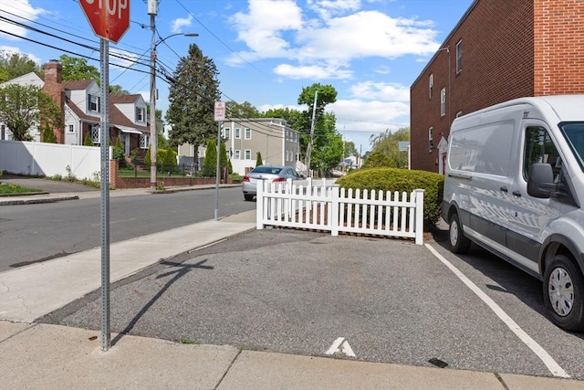 view of street with sidewalks, a residential view, street lights, and curbs