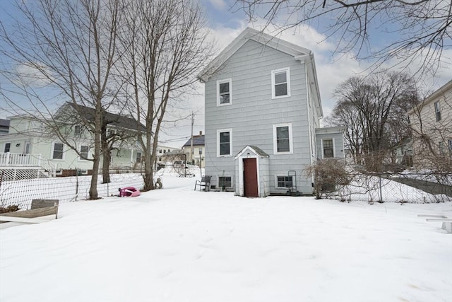 view of snow covered back of property