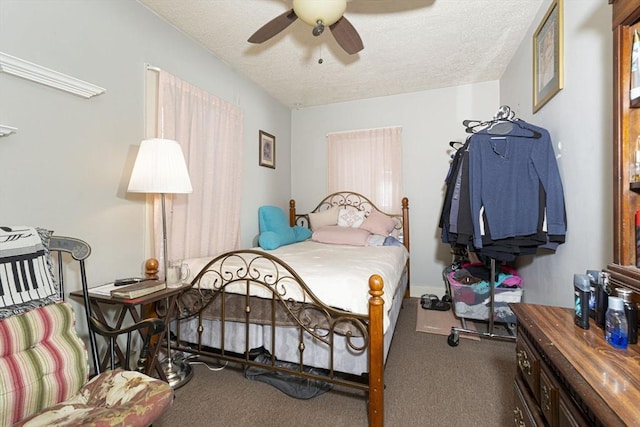 carpeted bedroom with ceiling fan and a textured ceiling