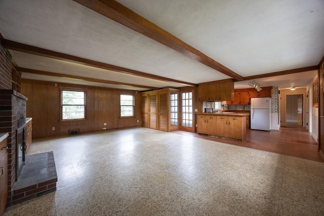 23 Crescent Ave, North Attleboro, MA 02760 - unfurnished living room with a brick fireplace, beam ceiling, and wood walls