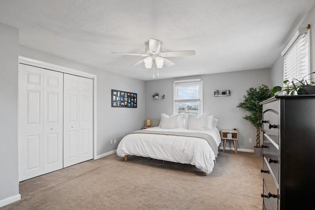 bedroom featuring ceiling fan, a closet, baseboards, and carpet flooring