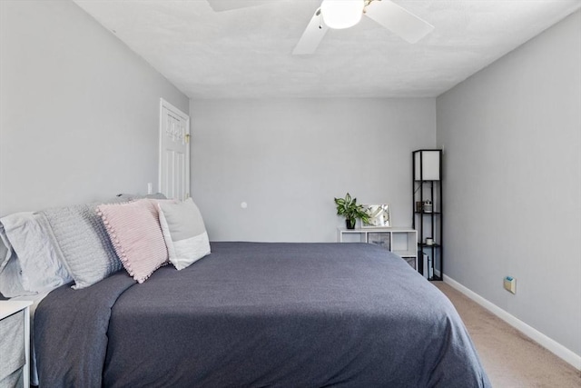 carpeted bedroom with ceiling fan and baseboards