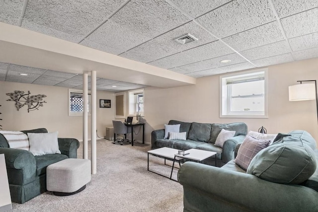 living area with a paneled ceiling, carpet flooring, visible vents, and baseboards