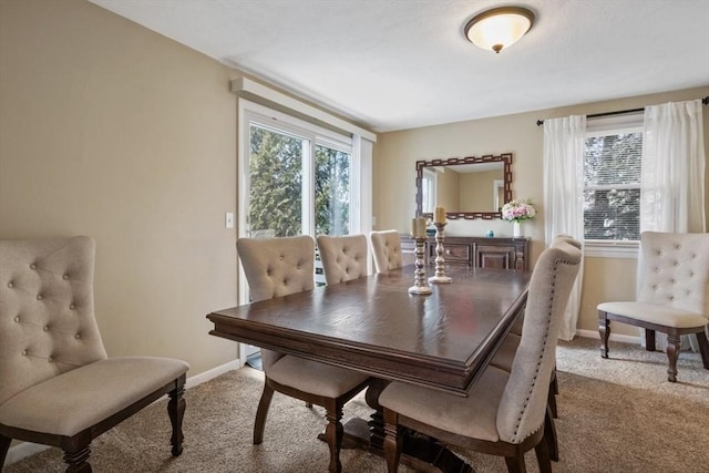 carpeted dining area featuring baseboards