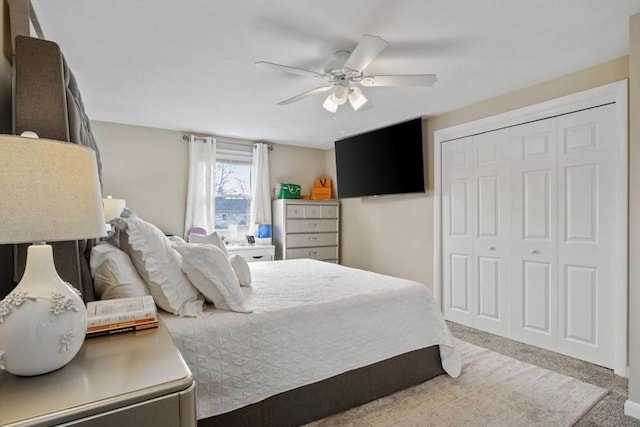 carpeted bedroom with ceiling fan and a closet