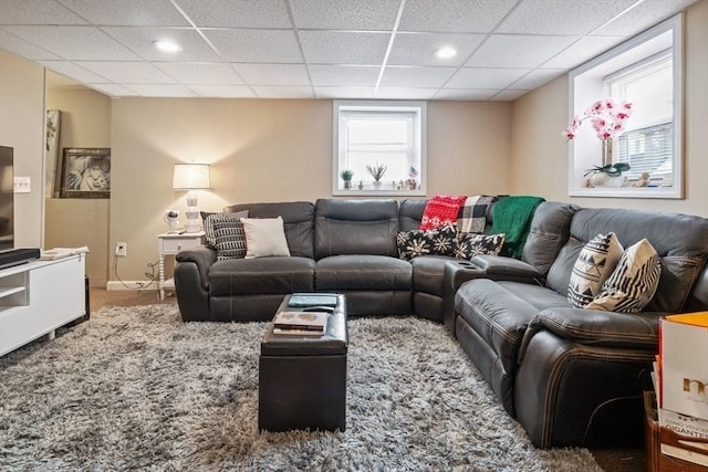 living room featuring carpet, a drop ceiling, baseboards, and recessed lighting