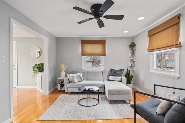 living room with ceiling fan, light wood-style flooring, and baseboards