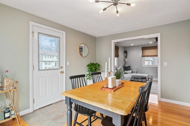 dining space with light wood-style flooring and baseboards