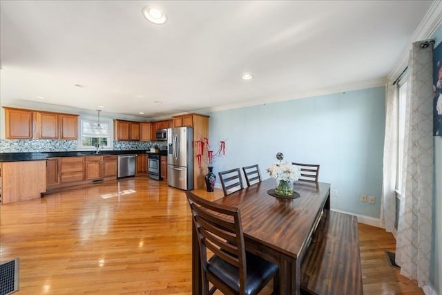 dining room with recessed lighting, baseboards, ornamental molding, and light wood-style flooring