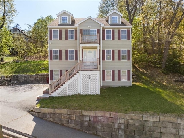 view of front of home with stairway and a front lawn