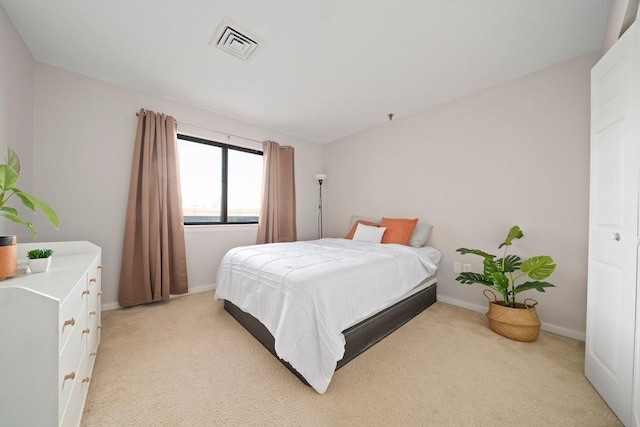 bedroom featuring baseboards, visible vents, and light colored carpet