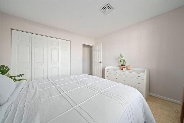 carpeted bedroom with a closet, visible vents, and baseboards