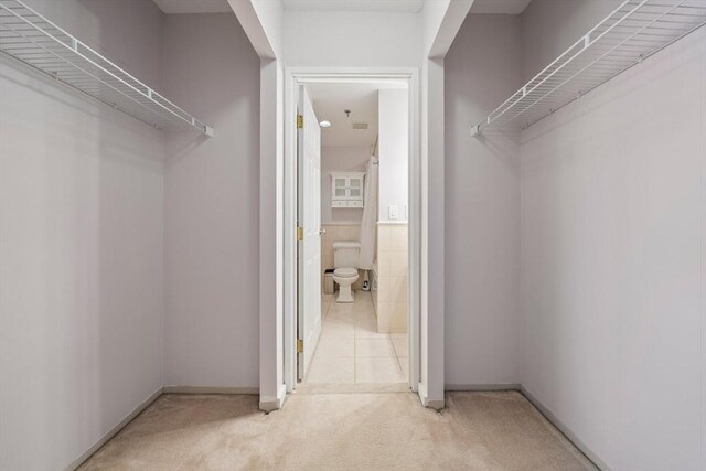 spacious closet with light colored carpet