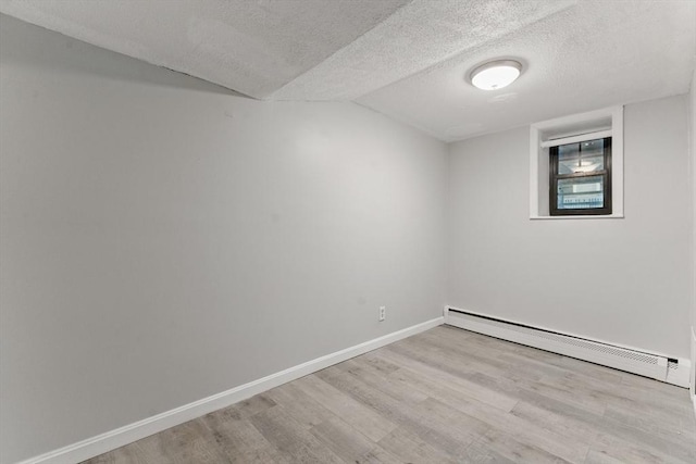 57 Brighton Ave Unit A, Boston, MA 02134 - empty room featuring a baseboard radiator, wood finished floors, a textured ceiling, vaulted ceiling, and baseboards