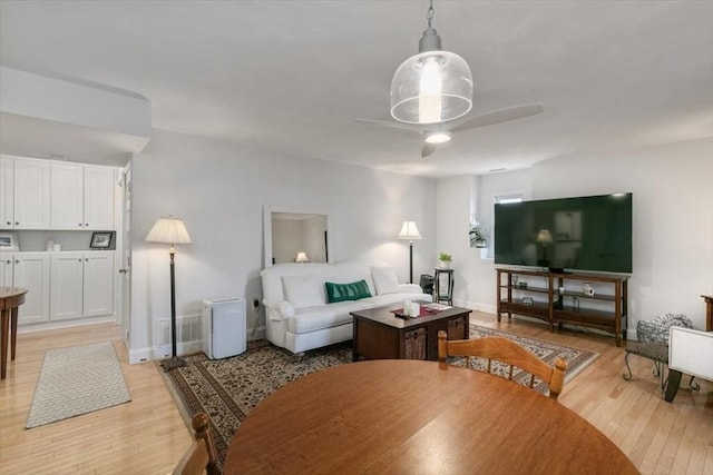 living room with light hardwood / wood-style floors and ceiling fan