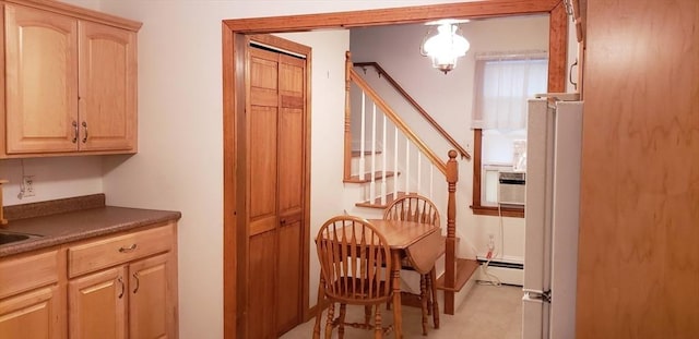 dining space featuring a baseboard radiator and stairs