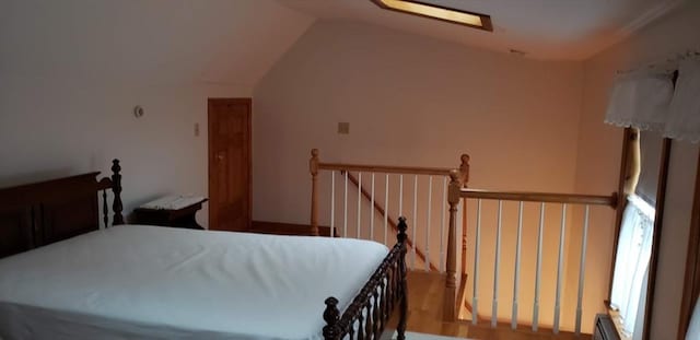 bedroom with lofted ceiling and wood finished floors
