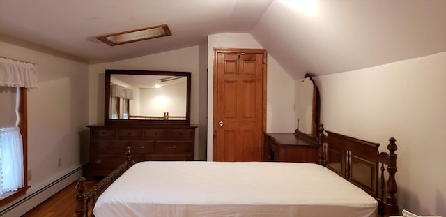 bedroom featuring a baseboard heating unit, attic access, vaulted ceiling, and dark wood finished floors