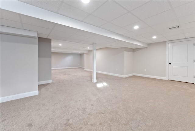 basement with light carpet and a paneled ceiling