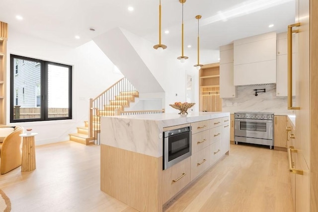 1597 Centre St Unit 2, Newton, MA 02461 - kitchen featuring stainless steel appliances, modern cabinets, light wood-type flooring, a center island, and recessed lighting