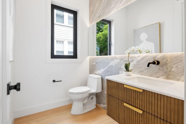 1597 Centre St Unit 2, Newton, MA 02461 - bathroom featuring wood finished floors, vanity, toilet, and baseboards