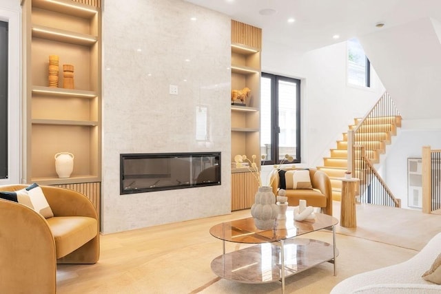 1597 Centre St Unit 2, Newton, MA 02461 - living room with built in features, a fireplace, a high ceiling, stairs, and recessed lighting