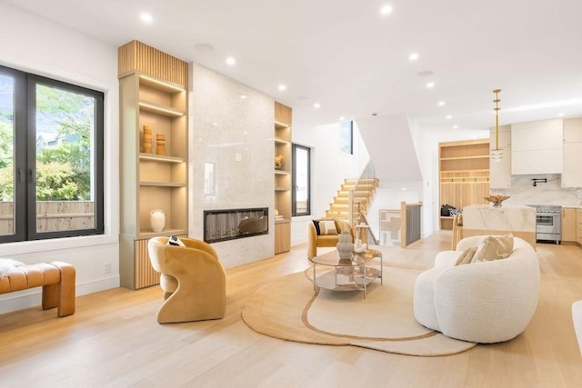 1597 Centre St Unit 2, Newton, MA 02461 - living area featuring a fireplace, stairs, recessed lighting, light wood-style floors, and built in shelves
