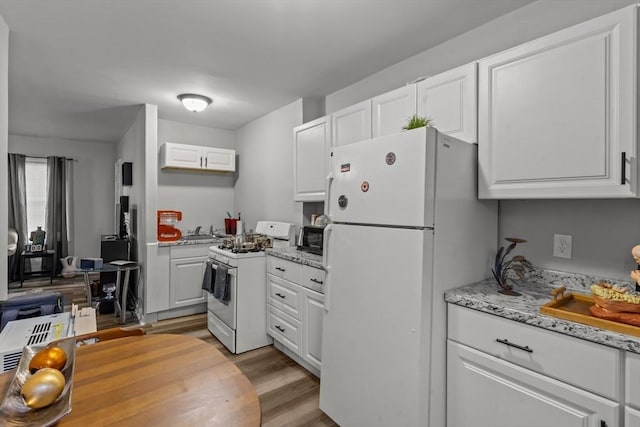 kitchen with white cabinets, light stone counters, white appliances, and light hardwood / wood-style floors