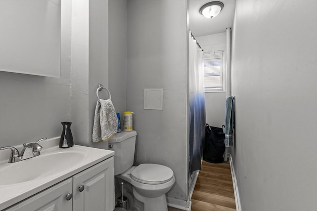 bathroom with toilet, vanity, and hardwood / wood-style flooring