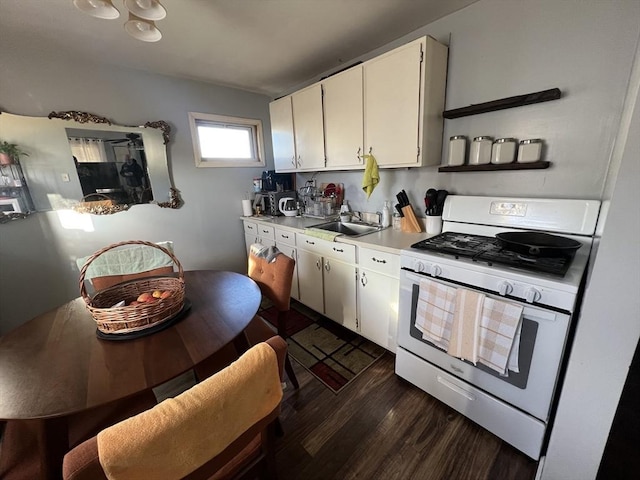 kitchen featuring sink, white cabinets, dark hardwood / wood-style flooring, and white gas range oven