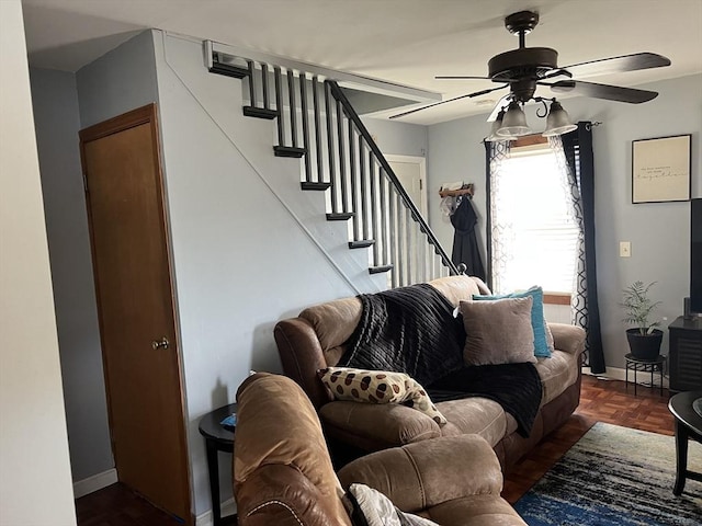 living room featuring ceiling fan and dark parquet floors