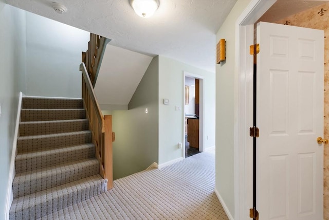 staircase with carpet floors and baseboards