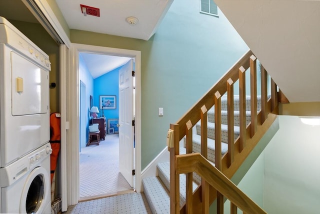 stairway with stacked washer and clothes dryer