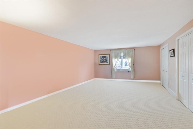 empty room featuring baseboards and carpet flooring